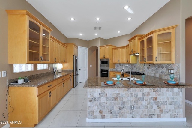 kitchen featuring kitchen peninsula, tasteful backsplash, stainless steel appliances, light tile patterned floors, and stone counters