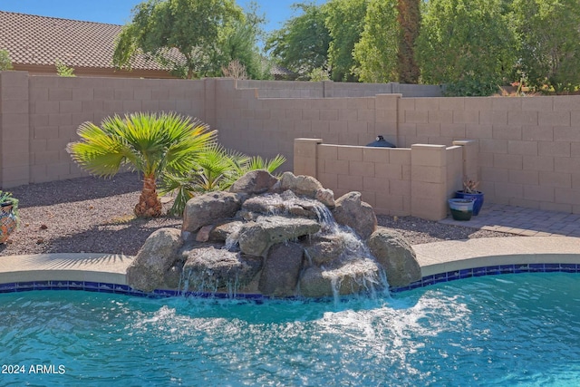 view of swimming pool with pool water feature