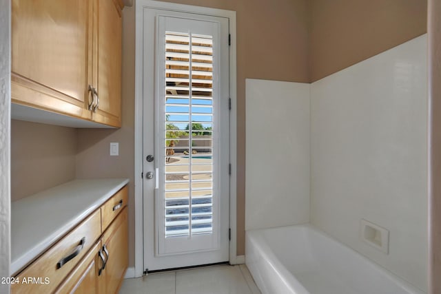 doorway to outside featuring a healthy amount of sunlight and light tile patterned floors