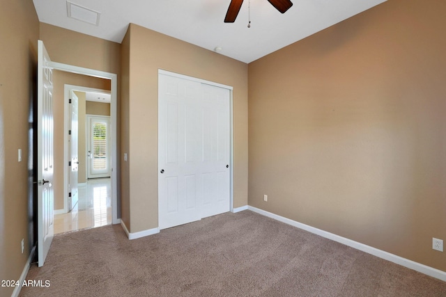 unfurnished bedroom featuring carpet floors, a closet, and ceiling fan