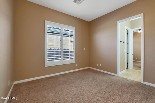 spare room featuring ceiling fan and light colored carpet