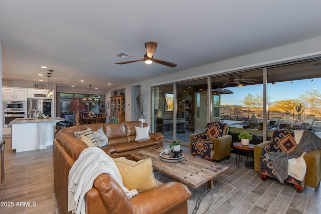 living area with recessed lighting, visible vents, wood finish floors, and ceiling fan