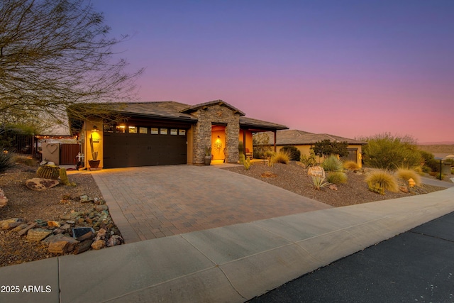 view of front of property with an attached garage, stone siding, and driveway