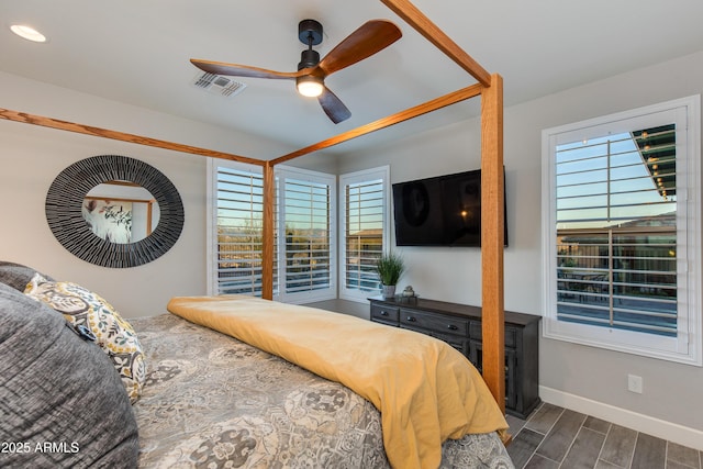 bedroom featuring multiple windows, baseboards, visible vents, and wood tiled floor