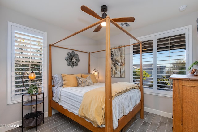 bedroom featuring visible vents, multiple windows, and wood finish floors