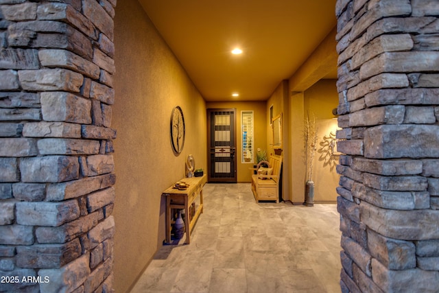 hallway with recessed lighting and a textured wall