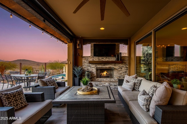 view of patio with an outdoor living space with a fireplace, a mountain view, and outdoor dining area