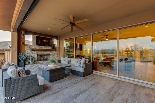 exterior space featuring an outdoor living space with a fireplace and a ceiling fan