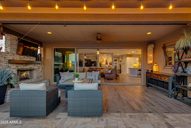 view of patio / terrace featuring a ceiling fan and an outdoor living space with a fireplace