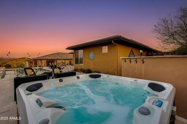 view of home's exterior featuring a hot tub and fence