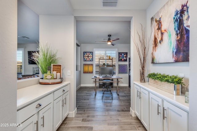 office space with a wealth of natural light, visible vents, a ceiling fan, and wood tiled floor