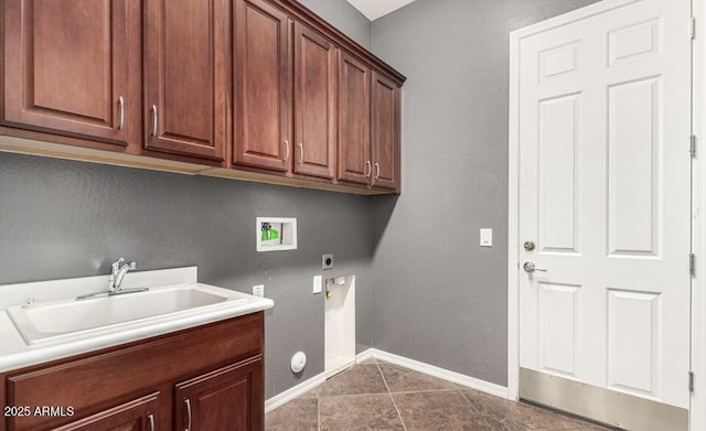 laundry area featuring sink, electric dryer hookup, hookup for a washing machine, cabinets, and dark tile patterned flooring