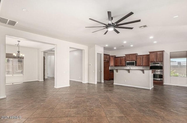 unfurnished living room with ceiling fan with notable chandelier