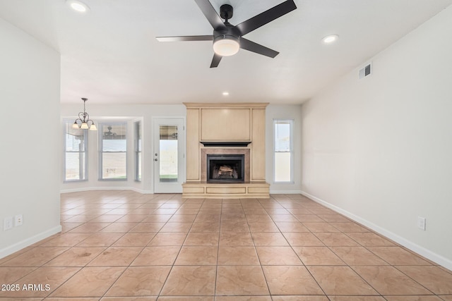 unfurnished living room with light tile patterned flooring, baseboards, visible vents, and a premium fireplace