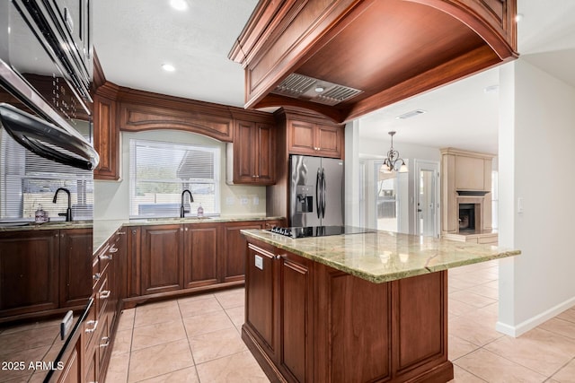 kitchen with visible vents, stainless steel refrigerator with ice dispenser, a center island, light tile patterned floors, and black electric cooktop