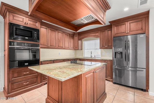 kitchen with visible vents, a center island, light stone countertops, light tile patterned flooring, and black appliances