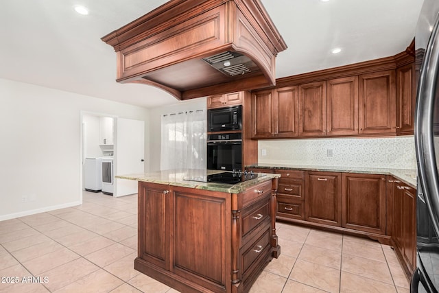 kitchen with black appliances, light stone counters, light tile patterned floors, and a kitchen island