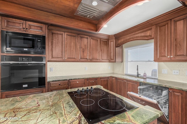 kitchen featuring black appliances, brown cabinetry, and a sink