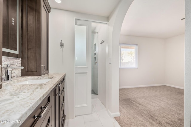 full bathroom with baseboards, a stall shower, and vanity