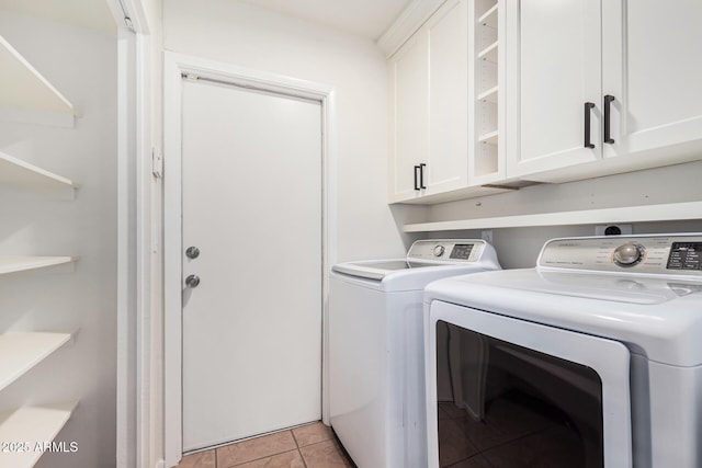 washroom with cabinet space, light tile patterned floors, and washer and dryer