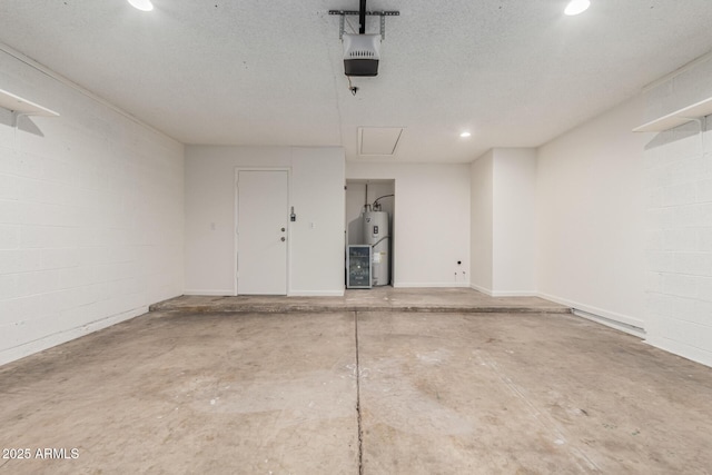 garage featuring recessed lighting, concrete block wall, a garage door opener, and water heater