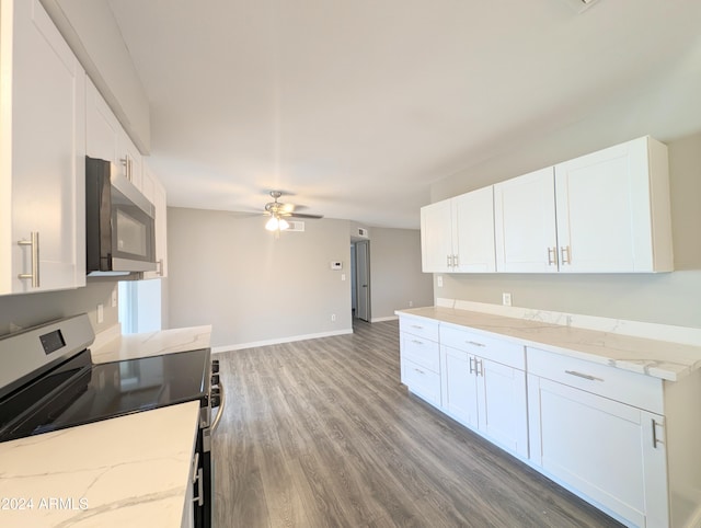 kitchen with stove, white cabinets, and light wood-type flooring