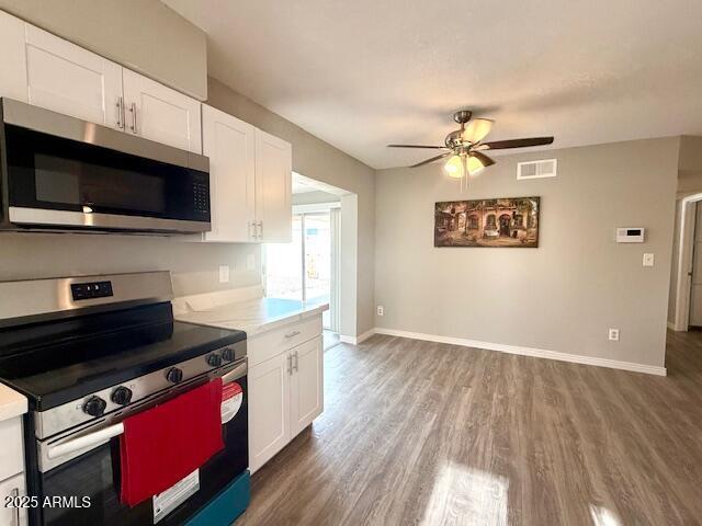 kitchen featuring appliances with stainless steel finishes, wood finished floors, ceiling fan, and white cabinets