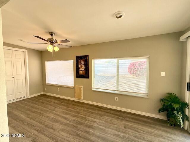 interior space with dark wood finished floors, baseboards, a ceiling fan, and a closet