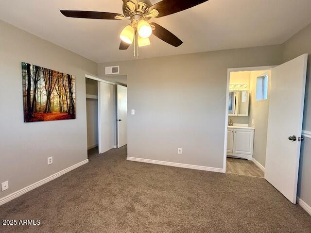 hallway featuring visible vents, wood finished floors, and baseboards