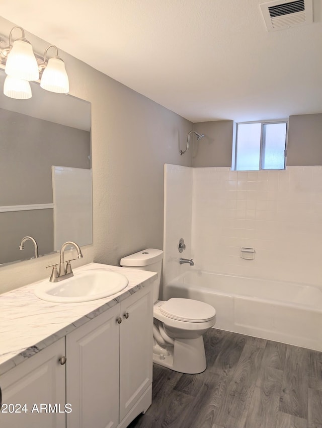 bathroom with wood finished floors, toilet, shower / washtub combination, vanity, and visible vents