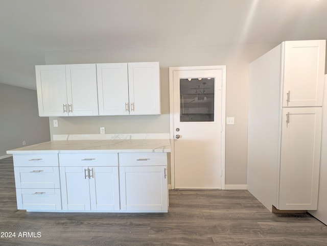 kitchen with light stone counters, baseboards, white cabinetry, and dark wood finished floors