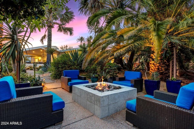 patio terrace at dusk featuring an outdoor living space with a fire pit