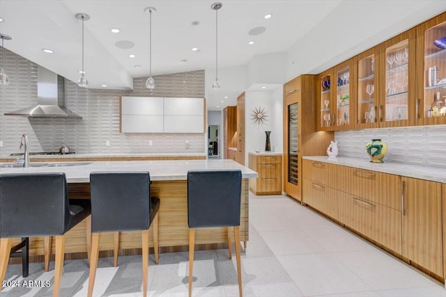 kitchen with hanging light fixtures, white cabinetry, tasteful backsplash, and fume extractor