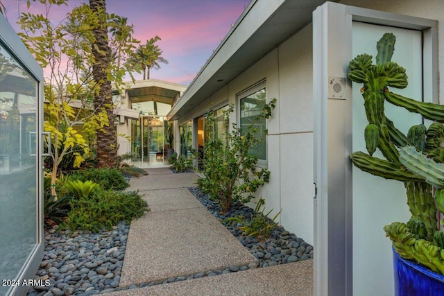 property exterior at dusk with a patio