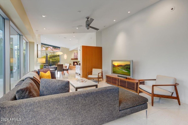 living room with lofted ceiling, ceiling fan, and light tile floors