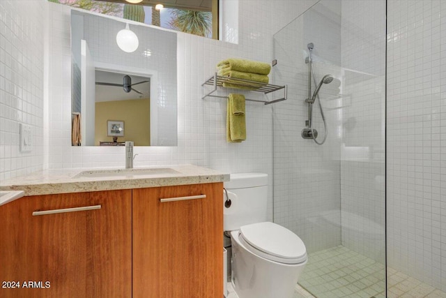 bathroom with tile walls, walk in shower, backsplash, toilet, and vanity