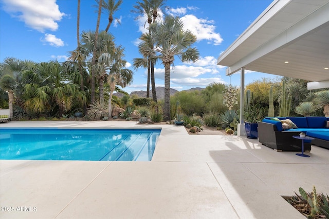 view of swimming pool featuring an outdoor living space, a mountain view, and a patio area