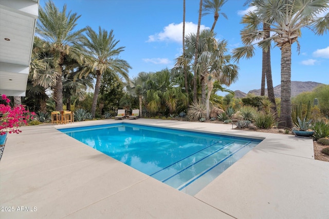 view of swimming pool with a mountain view and a patio area