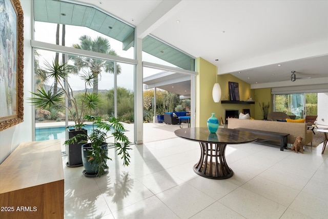 living room featuring vaulted ceiling with beams and a wall of windows