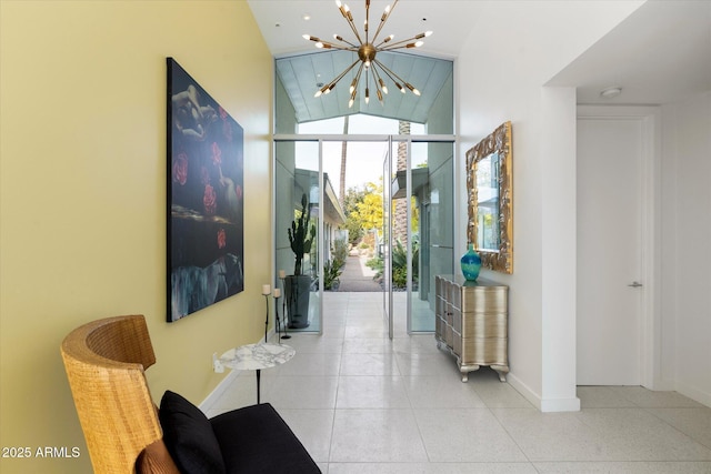 hall featuring an inviting chandelier, light tile patterned floors, and lofted ceiling