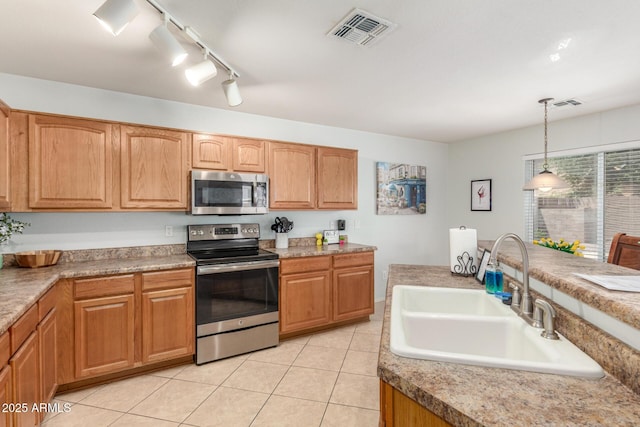 1142 E Mayfield Dr, San Tan Valley, AZ 85143 - kitchen with stainless steel appliances, a sink, pendant lighting, light tile patterned flooring, and rail lighting