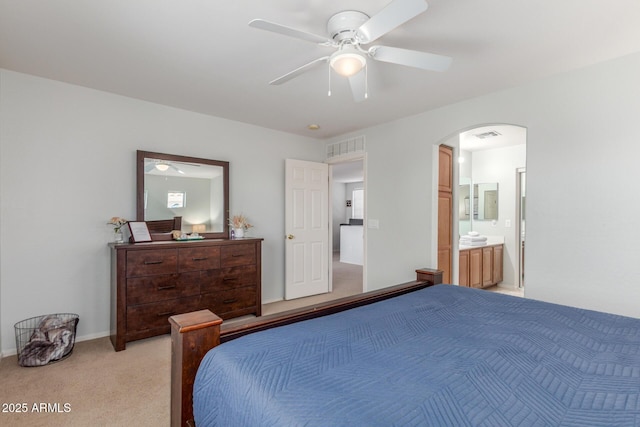 1142 E Mayfield Dr, San Tan Valley, AZ 85143 - bedroom featuring light carpet, arched walkways, ensuite bathroom, and a ceiling fan