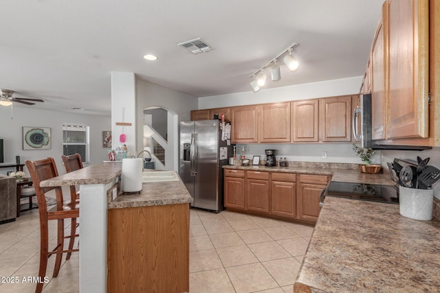 1142 E Mayfield Dr, San Tan Valley, AZ 85143 - kitchen with appliances with stainless steel finishes, a sink, arched walkways, a breakfast bar, and light tile patterned flooring