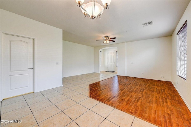 12775 W Lowden Rd, Peoria, AZ 85383 - spare room featuring arched walkways, light tile patterned flooring, a ceiling fan, and a chandelier