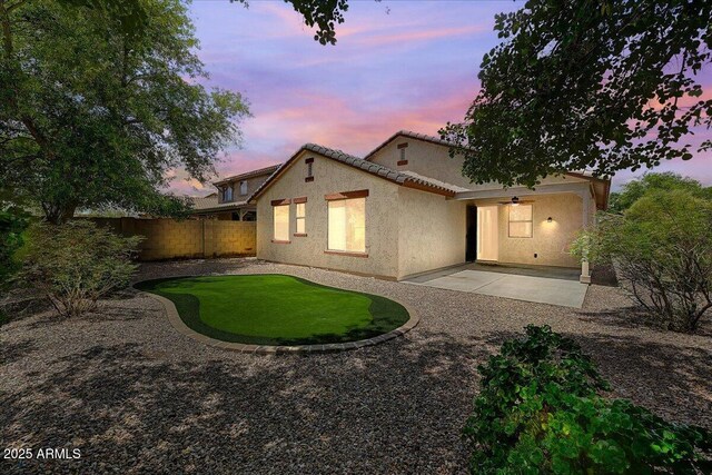 12775 W Lowden Rd, Peoria, AZ 85383 - back of house at dusk with a patio area, a fenced backyard, stucco siding, and ceiling fan