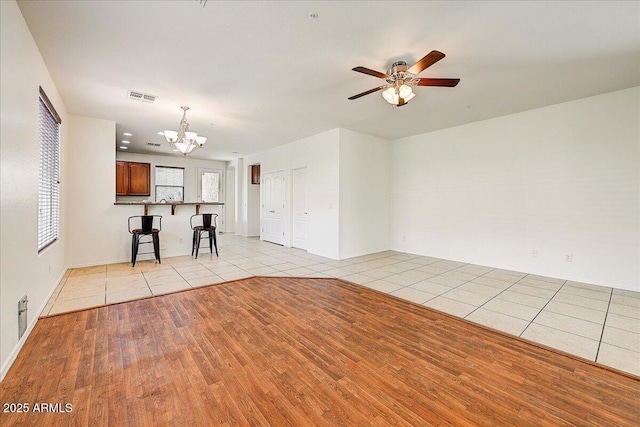 12775 W Lowden Rd, Peoria, AZ 85383 - unfurnished living room featuring light tile patterned floors, a chandelier, ceiling fan, and baseboards