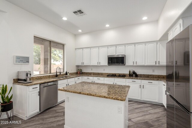 723 E Gemini Pl, Chandler, AZ 85249 - kitchen featuring appliances with stainless steel finishes, wood finished floors, dark stone countertops, white cabinets, and recessed lighting