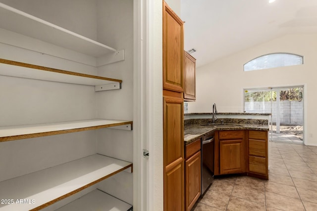 kitchen with lofted ceiling, dishwasher, kitchen peninsula, sink, and light tile patterned flooring