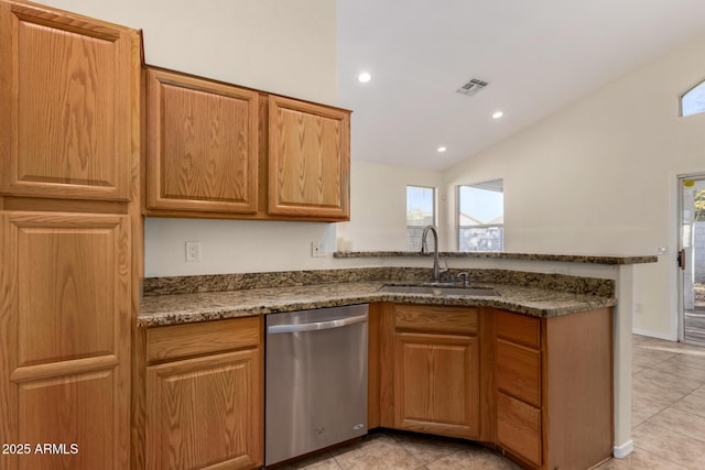 kitchen with lofted ceiling, dishwasher, dark stone counters, and sink