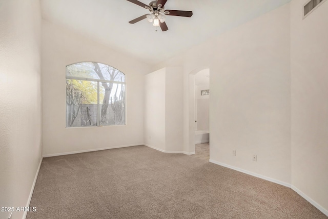 carpeted spare room with ceiling fan and vaulted ceiling